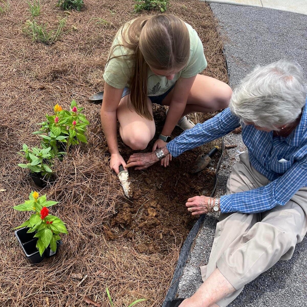 Resident gardening with family at Remember Me Senior Care